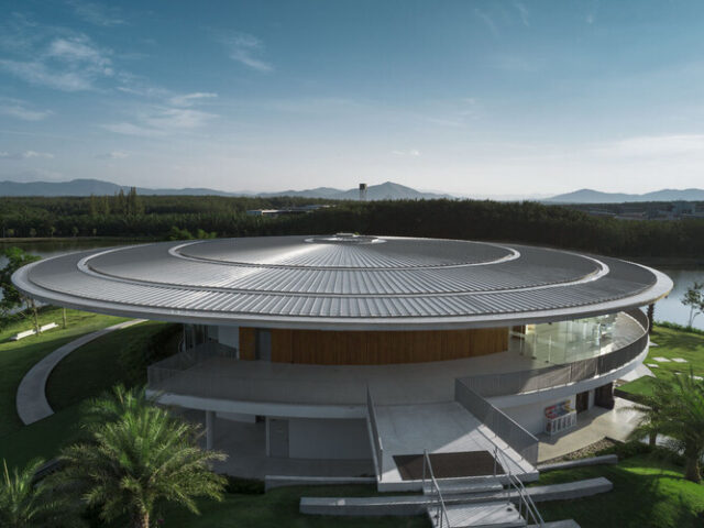 Exterior of the circular VISTEC Auditorium (K Building) surrounded by lawn and palms